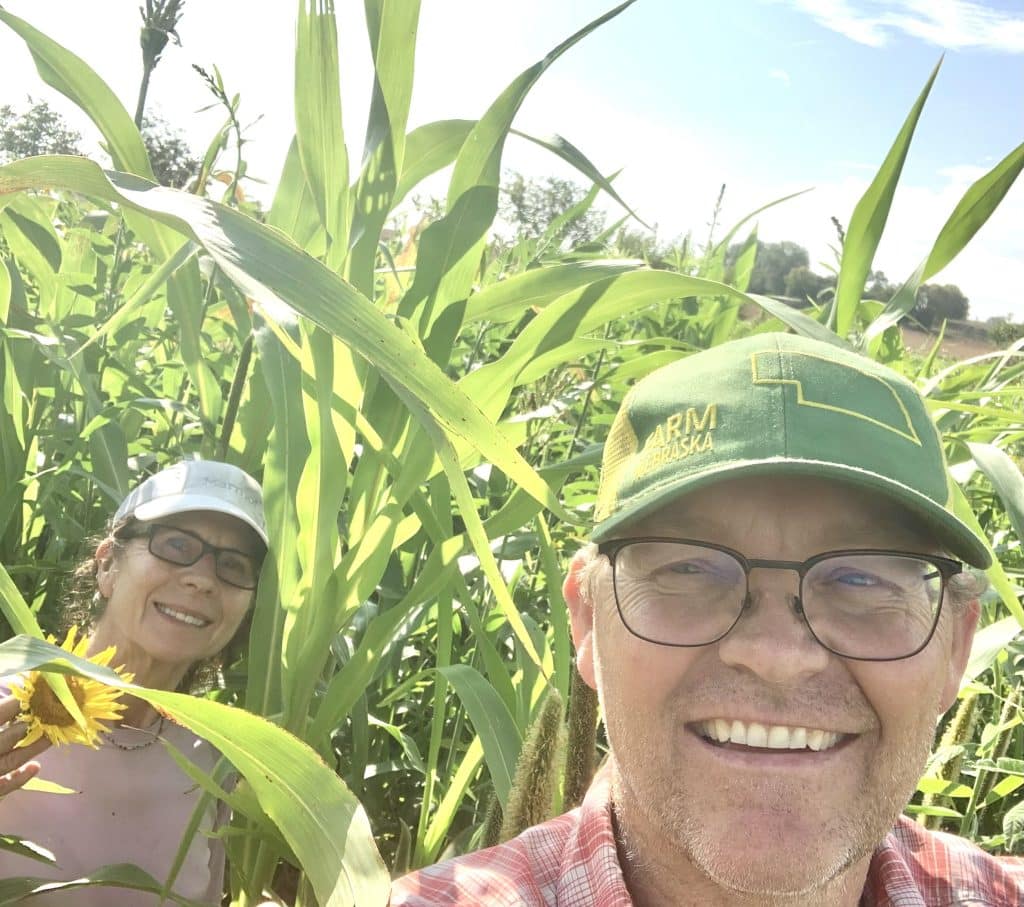 Mike McDonald smiling and standing in a corn field.