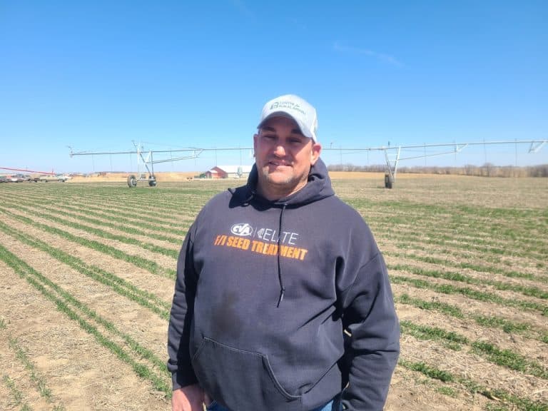 Greg Keller smiling and standing in a field.