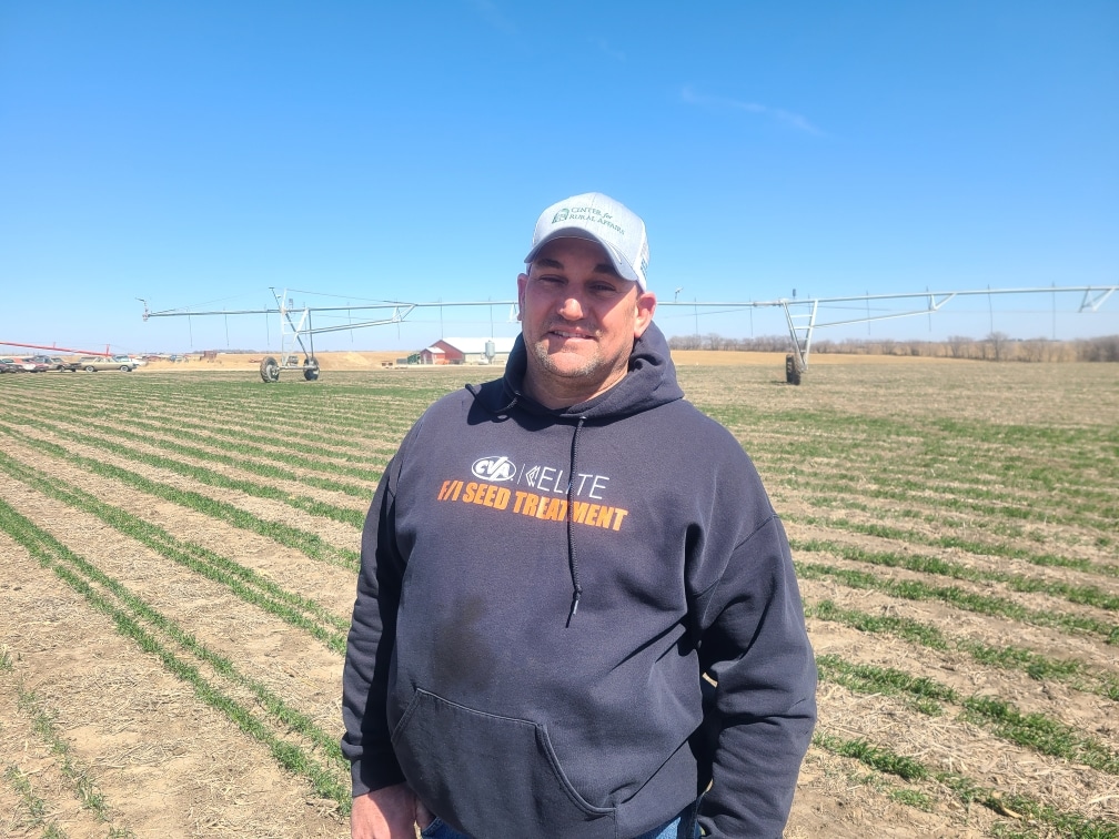 Greg Keller smiling and standing in a field.