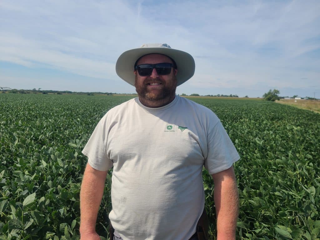 Will Corman smiling and standing a field.